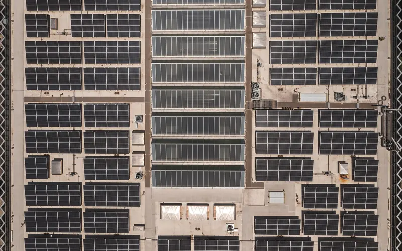 Aerial view of a large industrial rooftop covered with solar panel arrays